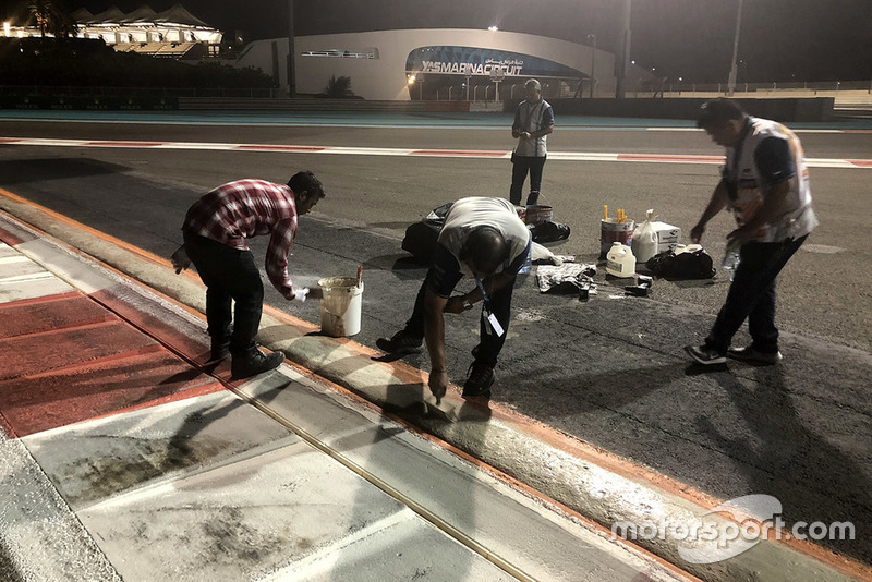 Pekerja memperbaiki kerb trek Yas Marina, Abu Dhabi