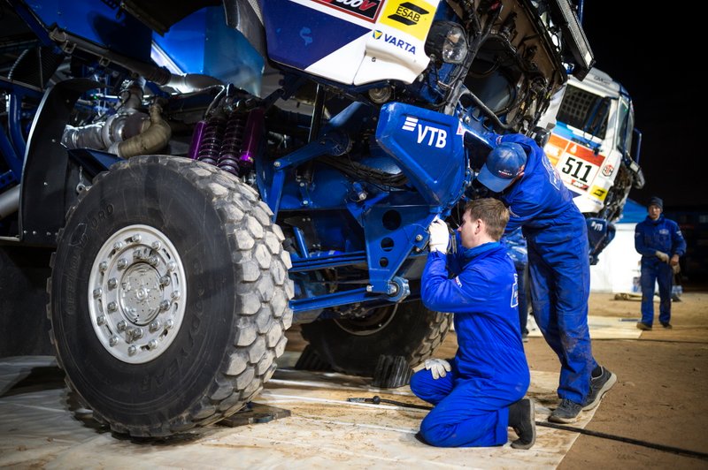 Team KAMAZ-Master monteurs werken na de etappe aan de wagen