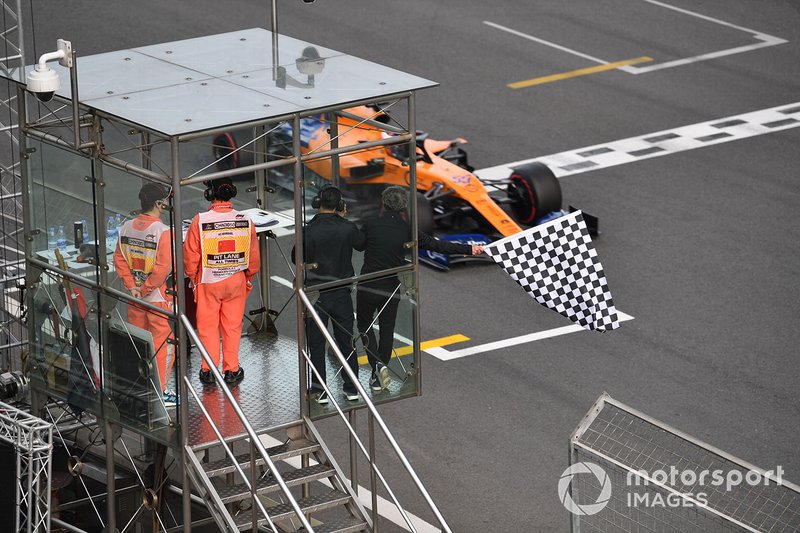 3 times world champion Alain Prost waves the chequered flag as Carlos Sainz Jr., McLaren MCL34 passes