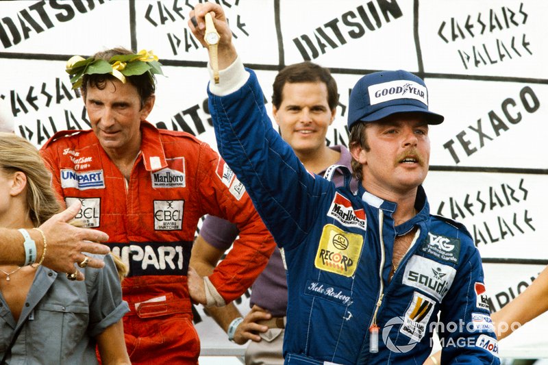 Keke Rosberg celebrates on the podium with John Watson