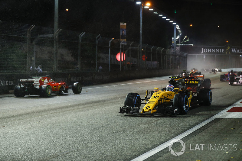 Jolyon Palmer, Renault Sport F1 Team RS17, passes the stricken car of Sebastian Vettel, Ferrari SF70H