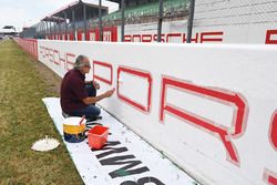 La peinture des publicités Porsche sur le bord du circuit