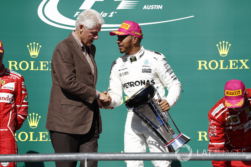 Former US President Bill Clinton presents Race winner Lewis Hamilton, Mercedes AMG F1, with the winn