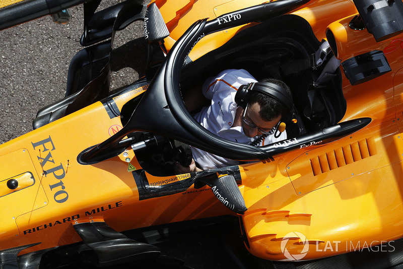 A McLaren mechanic sits in the Fernando Alonso McLaren MCL33 during a practice pit stop