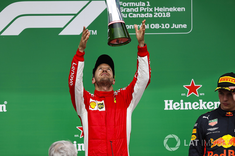 Sebastian Vettel, Ferrari, 1st position, tosses his trophy into the air in celebration on the podium