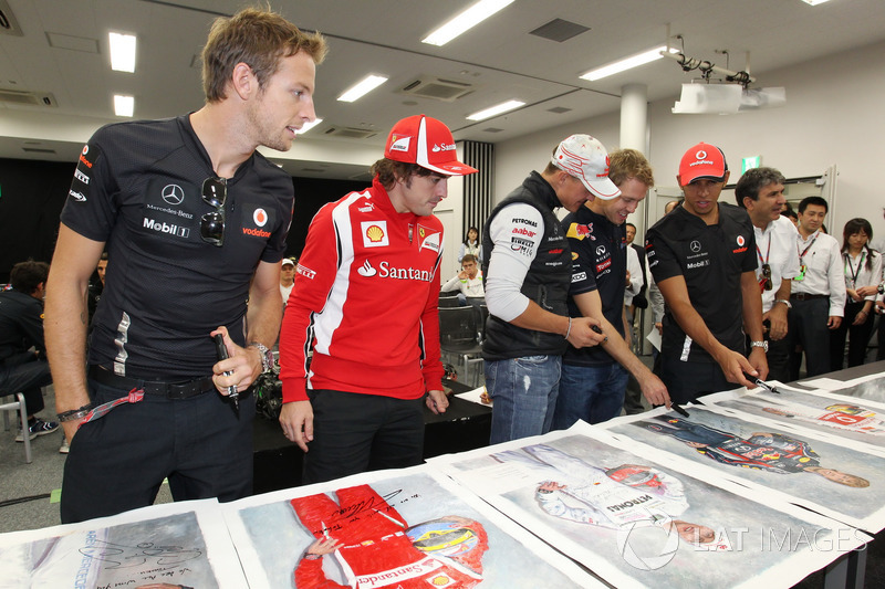 Jenson Button, McLaren, Fernando Alonso, Ferrari, Michael Schumacher, Mercedes GP, Sebastian Vettel, Red Bull Racing and Lewis Hamilton, McLaren firmano dei poster per beneficenza