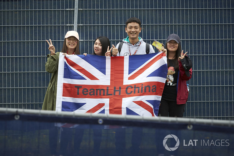 Los fanáticos de Lewis Hamilton, Mercedes AMG F1 W09, posan con una bandera