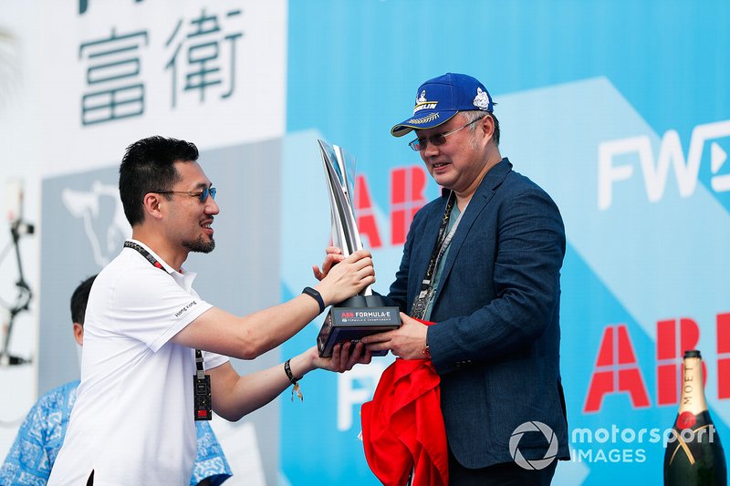 A DS TECHEETAH representative on the podium with the winner's trophy