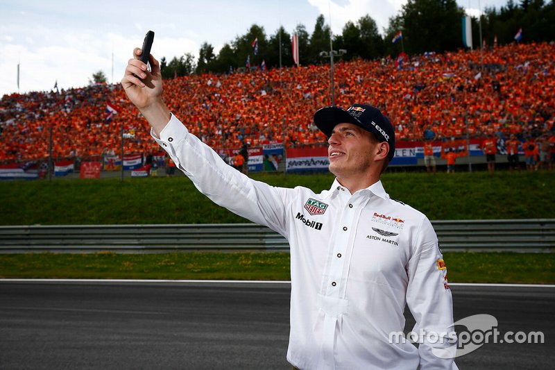 Max Verstappen, Red Bull, takes a photo with his Dutch fans in the background