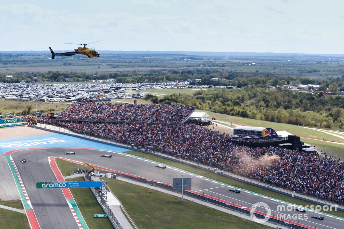 George Russell, Williams FW43B, Nikita Mazepin, Haas VF-21, Mick Schumacher, Haas VF-21, y el resto del pelotón mientras un helicóptero con cámara Eurocopter AS 350 B3 Squirrel capta la acción