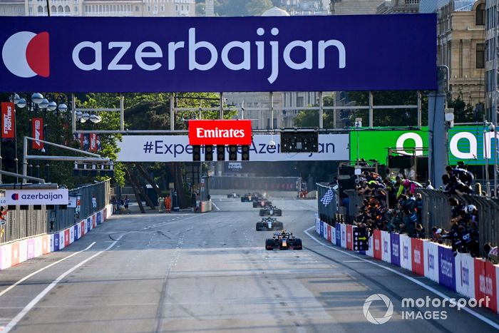 Sergio Pérez, Red Bull Racing RB16B, 1ª posición, toma la bandera a cuadros para alegría de su equipo en el muro de boxes