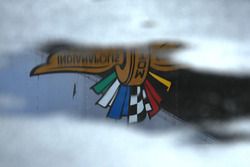 El logo de Indianapolis Motor Speedway se refleja en un charco de agua de lluvia