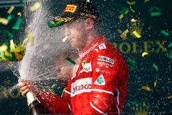 Sebastian Vettel, Ferrari, con lo champagne sul podio dopo la vittoria della gara