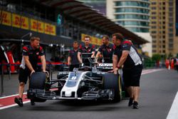 Des membres de Haas F1 Team poussent la voiture de Romain Grosjean Haas F1 Team VF-17 dans la pitlane