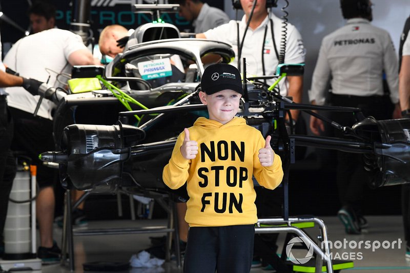 Юный болельщик на фоне Mercedes AMG F1 W10 Льюиса Хэмилтона
