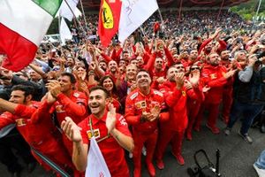 The Ferrari team gather to celebrate victory at the podium