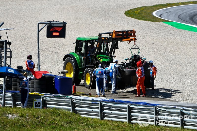 Los oficiales retiran el coche dañado de Valtteri Bottas, Mercedes AMG W10