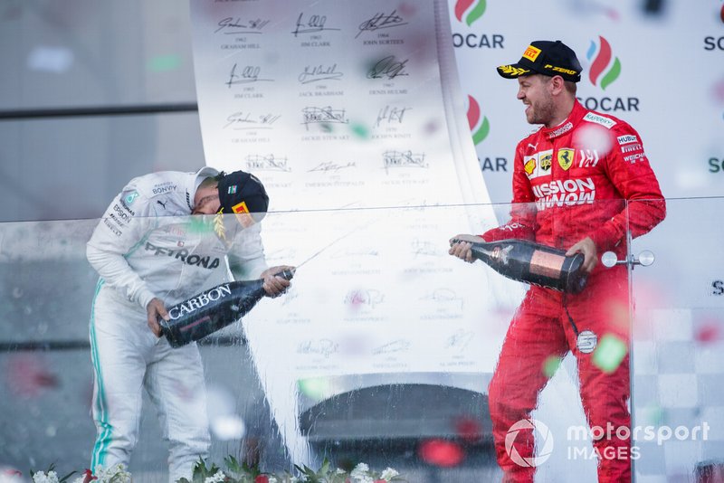 Valtteri Bottas, Mercedes AMG F1, vincitore, e Sebastian Vettel, Ferrari, terzo, festeggiano sul podio con lo champagne