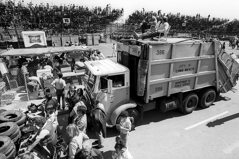 Photographers gather at the bottom of Linden Avenue to shoot the race, as two city workers decide to use their dumpster truck as a great vantage point