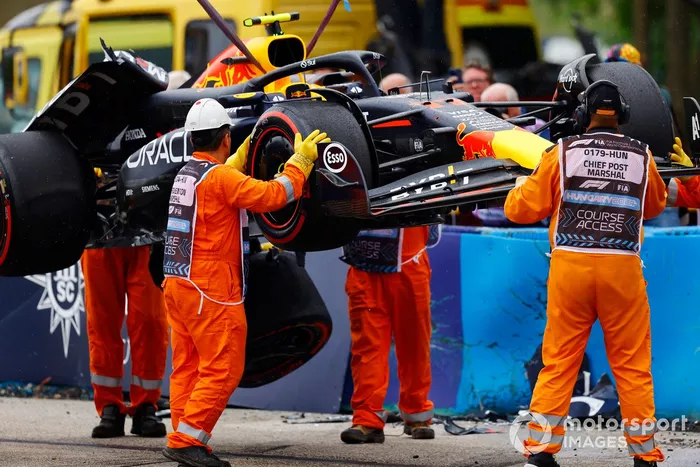 Los comisarios retiran el coche dañado de Sergio Pérez, Red Bull Racing RB20