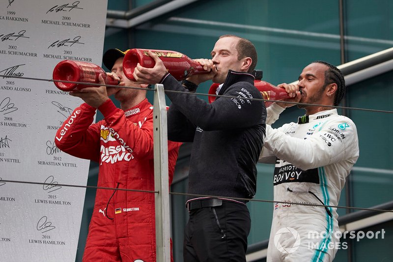 Sebastian Vettel, Ferrari, 3rd position, the Mercedes Constructors trophy delegate and Lewis Hamilton, Mercedes AMG F1, 1st position, drink Champagne on the podium