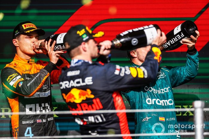 Lando Norris, McLaren, 2ª posición, Max Verstappen, Red Bull Racing, 1ª posición, Fernando Alonso, Aston Martin F1 Team, 3ª posición, beben Champán en el podio.