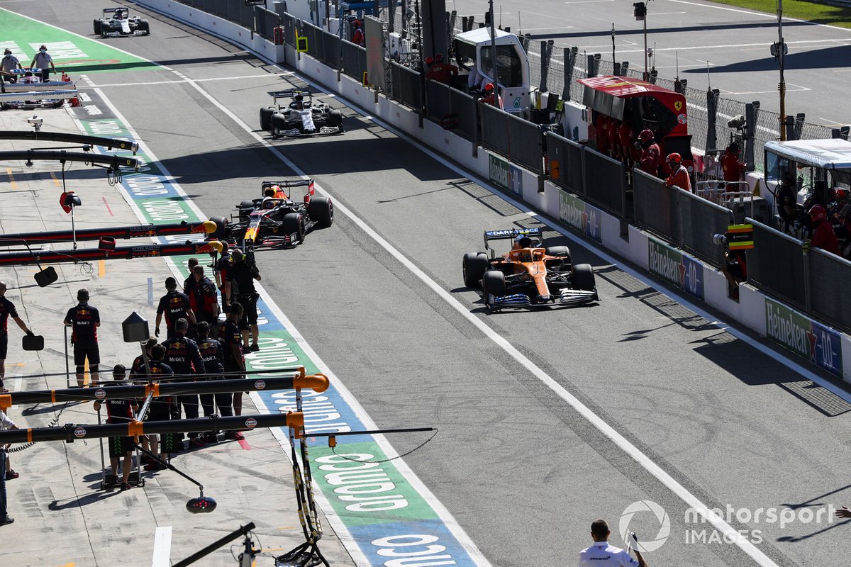 Carlos Sainz Jr., McLaren MCL35, e Max Verstappen, Red Bull Racing RB16, si dirigono ai box