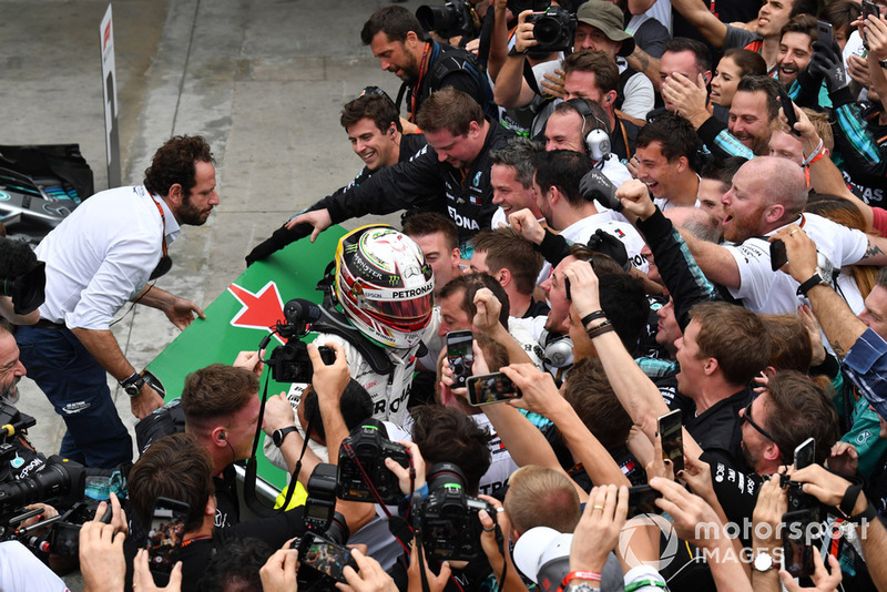 Las barreras se derrumban cuando Lewis Hamilton, Mercedes AMG F1 celebra con su mecánica en el Parc Ferme.