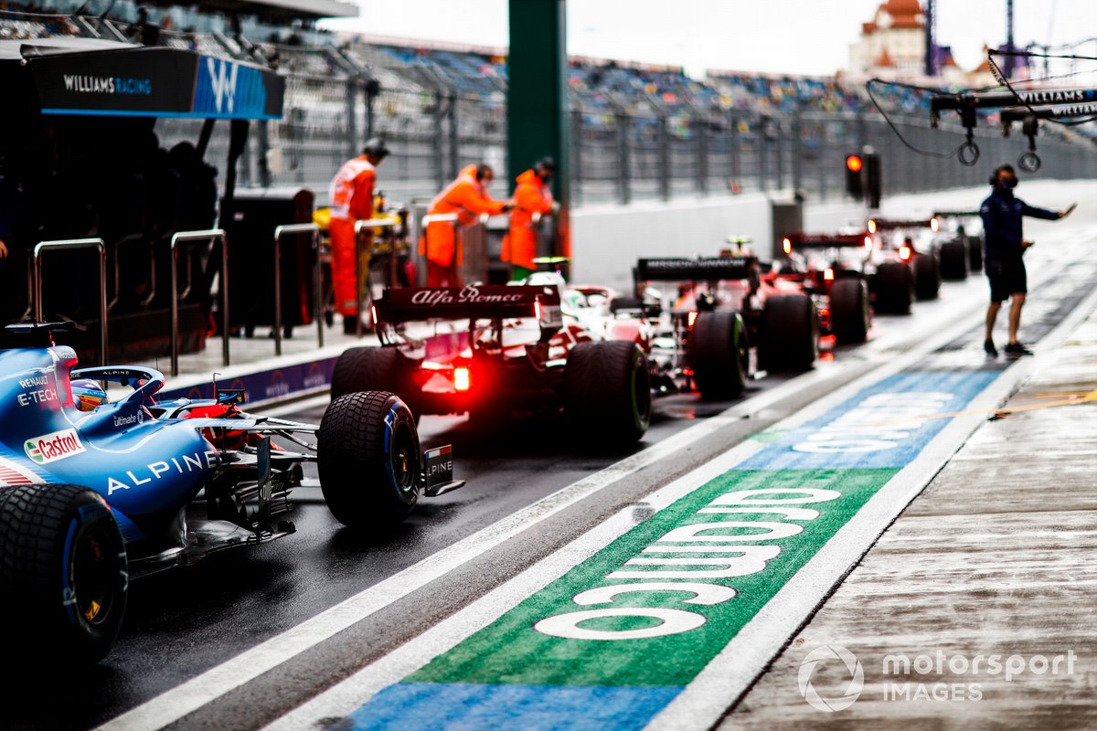 Carlos Sainz Jr., Ferrari SF21, Antonio Giovinazzi, Alfa Romeo Racing C41, y Fernando Alonso, Alpine A521, en la fila para salir de boxes