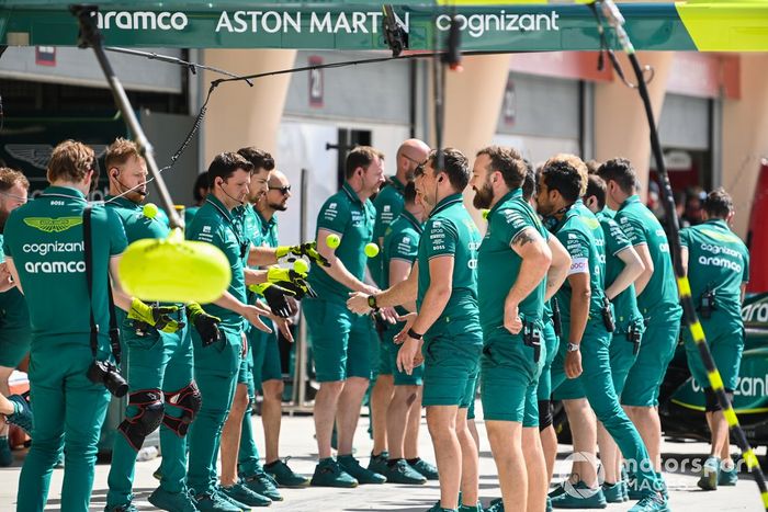 Los mecánicos de Aston Martin realizan ejercicios en el pit lane
