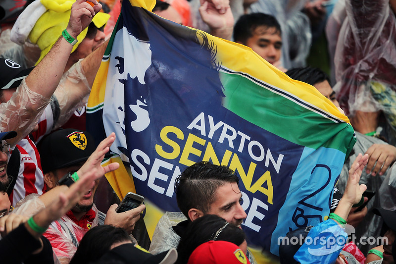 A Ayrton Senna banner with fans at the podium