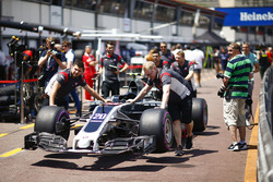 Mechanics push the newly-liveried car of Kevin Magnussen, Haas F1 Team VF-17, in the pits