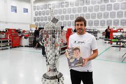 Fernando Alonso with the Borg-Warner trophy and the 1981 Indy 500 yearbook