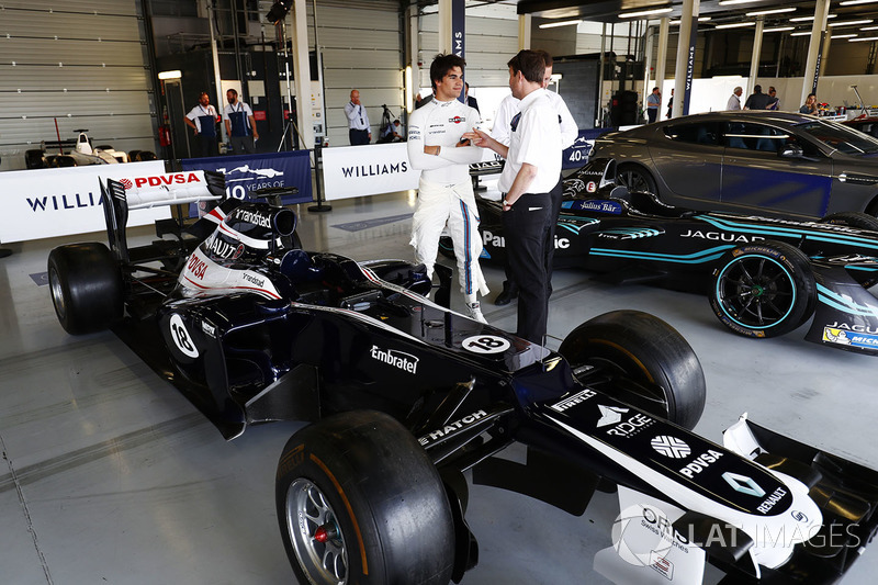 Lance Stroll, Williams, stands between a 2012 Williams FW34 Renault Sport F1 Team and Jaguar Formula E car