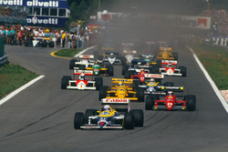 Nigel Mansell, Williams FW11B Honda, lidera a Gerhard Berger, Ferrari F187, Ayrton Senna, Lotus 99T Honda, Nelson Piquet, Williams FW11B Honda, y Alain Prost, McLaren MP4/3 TAG Porsche, al inicio