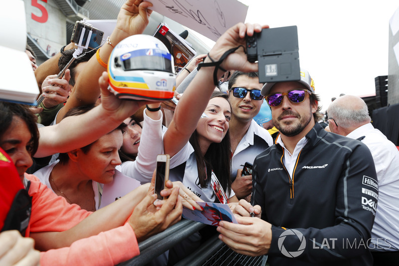 Fernando Alonso, McLaren, signs autographs for fans