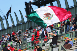 Fans in the grandstand and a man with a Mexican flag