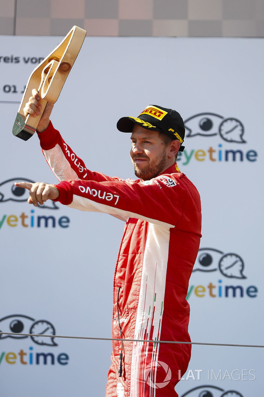 Sebastian Vettel, Ferrari, 3rd position, lifts his trophy on the podium