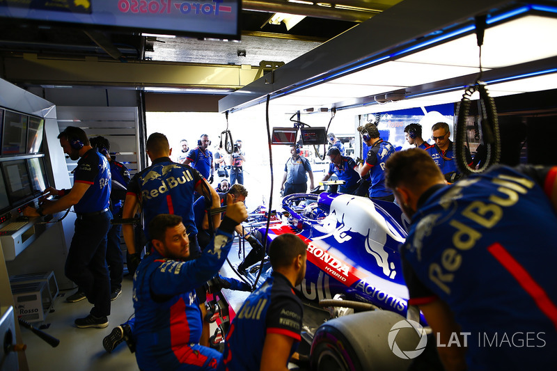 Mechanics work on the Brendon Hartley Toro Rosso in the team's garage