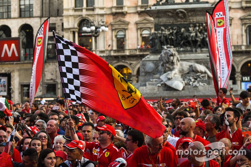 A Ferrari flag waves amidst the crowd