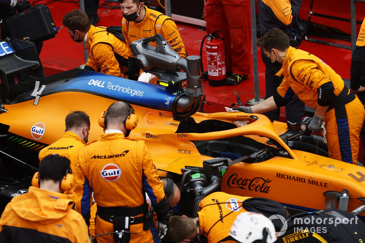 Los mecánicos trabajan en el coche de Lando Norris, McLaren MCL35M