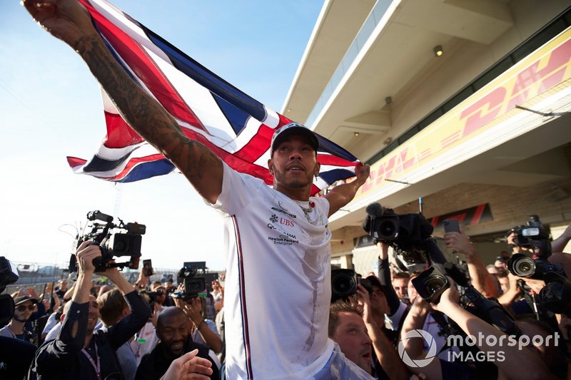 Lewis Hamilton, Mercedes AMG F1, lifts a Union Flag after winning the world championship