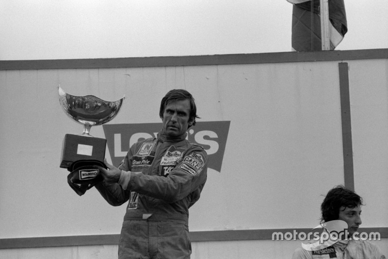 Ganador de la carrera Carlos Reutemann, Williams (Izquierda) con una celebración silenciosa en el podio con Riccardo Patrese en tercer lugar, Arrows (derecha). Carlos no pudo observar las órdenes del equipo dadas durante la carrera para dejar pasar a su compañero de equipo Alan Jones. Jones se negó a aparecer en el podio por ello