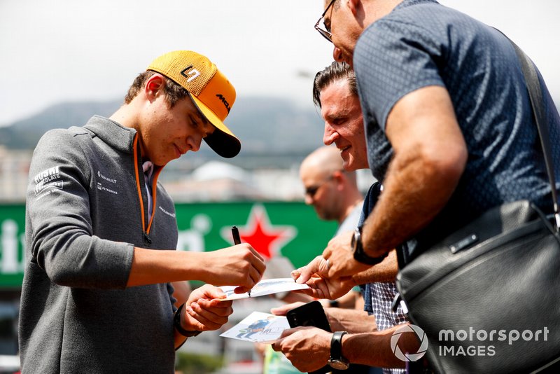 Lando Norris, McLaren signs a autograph for a fan