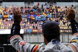 Fernando Alonso, McLaren, waves to fans in a grandstand