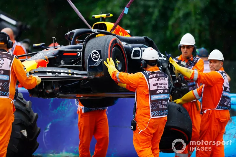Görevliler Red Bull Racing RB20 sürücüsü Sergio Perez'in hasarlı aracını kaldırıyor