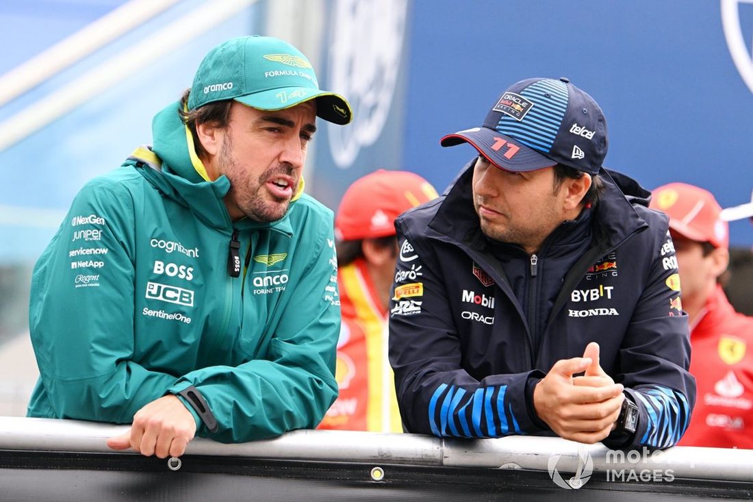 Fernando Alonso, Aston Martin F1 Team, rozmawia z Sergio Perezem, Red Bull Racing, podczas parady kierowców. 