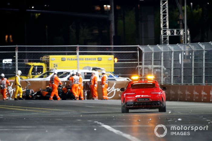 Los comisarios y el coche médico con el coche accidentado de Lando Norris, McLaren MCL60