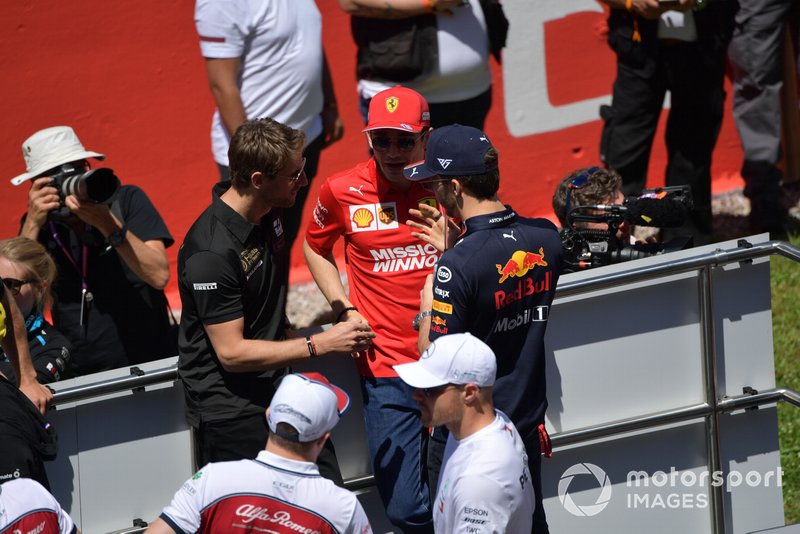 Romain Grosjean, Haas F1, Charles Leclerc, Ferrari, and Pierre Gasly, Red Bull Racing, talk at the drivers parade