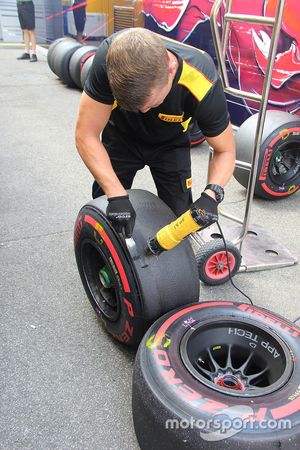 Pirelli technitian scraping the tyres used in the practice session